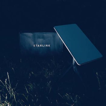 Germany - Jun 16, 2023: Cardboard parcel in backyard at night. Flash photography, no people. Is it a SpaceX Starlink delivery, setting up communication anywhere, even in wilderness spots