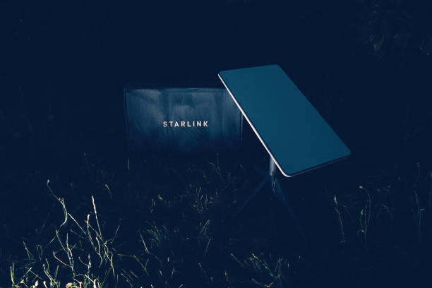 Germany - Jun 16, 2023: Cardboard parcel in backyard at night. Flash photography, no people. Is it a SpaceX Starlink delivery, setting up communication anywhere, even in wilderness spots